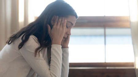 Awful day! Profile view of stressed depressed frustrated teen girl sitting at home alone with closed...