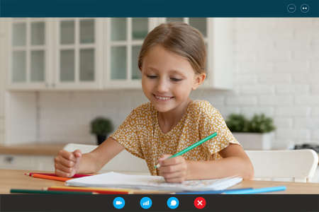 Smiling small Caucasian kid have fun drawing studying online on computer from home. Happy little...