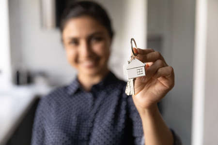 Crop close up blurred background of woman show keys buy new apartment or house. Happy excited female...