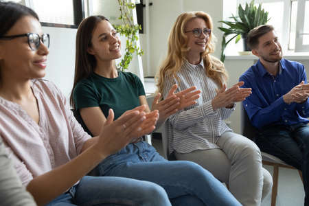 Perfect lecture. Happy smiling diverse multiethnic audience corporate staff workforce attending on training presentation applauding clapping hands expressing gratitude respect to trainer speaker coachの写真素材