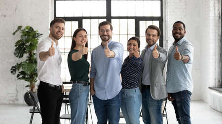 Sign of quality. Group of six diverse multiethnic young people clients customers standing in line...