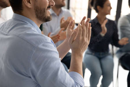 Excellent report. Close up of diverse multiethnic audience millennial men and women sitting on chairs clapping hands to speaker lecturer appreciating for good speech grateful for useful informationの写真素材