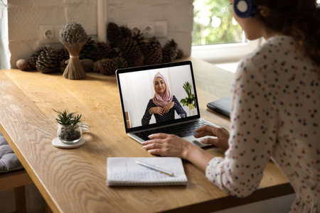 Back view of female employee have webcam digital virtual conference online meeting with...