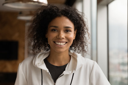 Profile picture of smiling young African American woman talk on video call in office. Headshot...