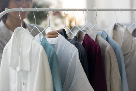 Made with love. Close up view of man shirts exhibition samples on hanger at atelier or ready made shop. New brand collection of handmade business style clothes created by fashion designer couturierの写真素材