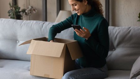 Excited young Caucasian woman unbox cardboard package shopping online from home. Happy millennial...