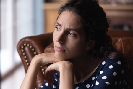 Pensive young Caucasian woman look in distance thinking or pondering of personal problems. Unhappy sad thoughtful millennial female lost in thoughts, feel distressed lonely at home. Solitude concept.の写真素材