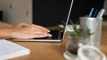 Close up of young woman remote worker employee student freelancer using laptop device at home office...
