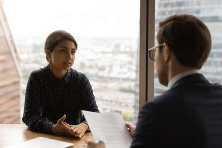 Close up Cauciasian hr manager interviewing confident Indian businesswoman, recruiter employer...