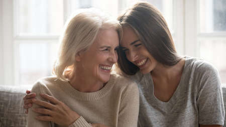 Overjoyed millennial Caucasian woman embrace happy older 60s mom enjoy family weekend reunion...