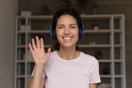 Nice to meet you. Portrait of happy smiling millennial latina female in headset look forward speak...