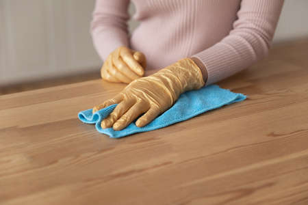 Easy housecleaning. Close up shot of young female hands in thin latex protective gloves using blue...