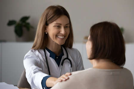 Happy young Caucasian female doctor support senior patient at meeting in clinic. Smiling woman GP or nurse show support care to elderly client in hospital. Good medical service, healthcare concept.の写真素材