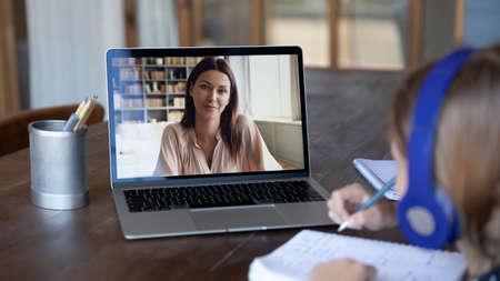 Screen view of primary school female teacher holding virtual lesson for kids from home. Schoolgirl...
