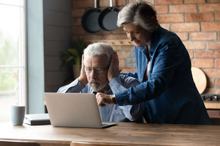 Couple buy together online services, caring wife provide simple guidance to puzzled old 70s husband while use laptop. Older gen barriers and perceptions difficulties of modern technology usage conceptの写真素材