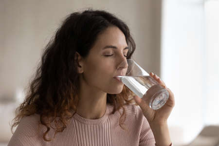 Young Hispanic woman hold glass drink pure mineral clean water recommend healthy lifestyle....