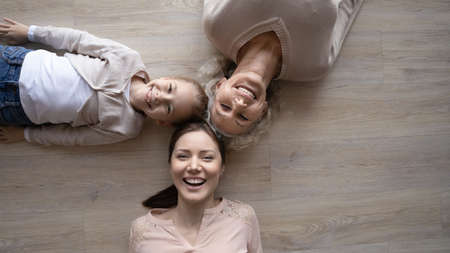 Happy cheerful family of elderly grandmother young adult mother and little preteen girl daughter...