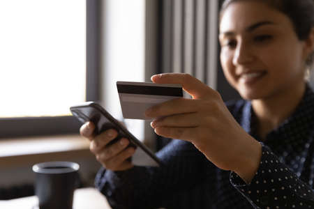Freelancer, entrepreneur, Indian business woman using mobile bank system, smartphone and credit card...