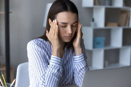 Close up unhealthy businesswoman with closed eyes touching head massaging temples, suffering from...