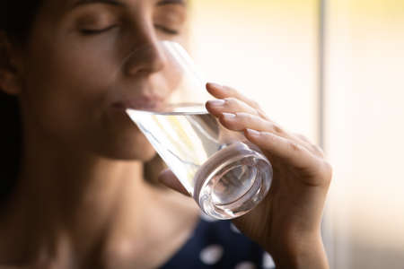Pleasure in every sip. Close up shot of thirsty millennial hispanic woman with closed eyes drinking...