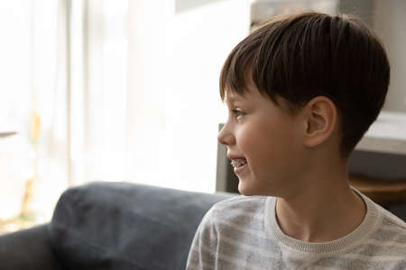 Head shot dreamy happy little preteen child boy in braces or plates for teeth looking in distance, copy space for advertising text, professional stomatology services for kids, healthy toothy smile.の写真素材
