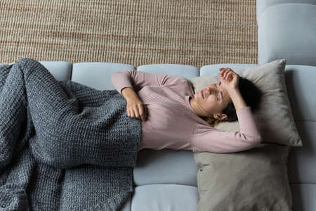 Top view unhappy woman touching forehead, suffering from headache, chronic insomnia or migraine,...