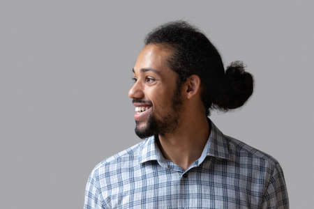 Head shot dreamy happy young African American bearded man looking in distance, feeling excited of...