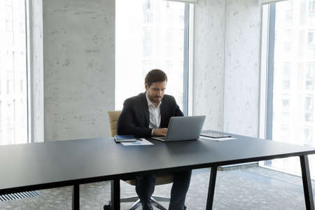 Focused young Caucasian businessman executive manager leader director boss in formal suit working on...