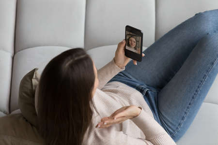 Woman holds cell phone looks at device cam, record video blog for channel subscribers, greets...