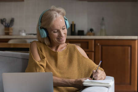 Happy senior 50s online course student woman watching learning webinar, attending virtual lesson,...