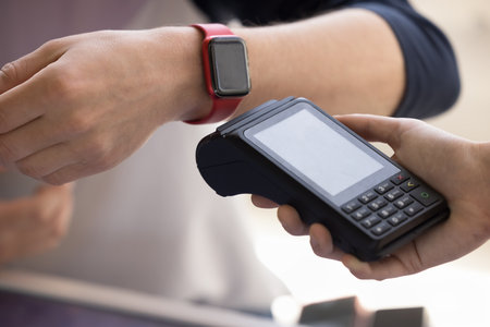 Wireless payment via smart watch using NFC tech, close up shot. Unrecognizable male buyer, customer...