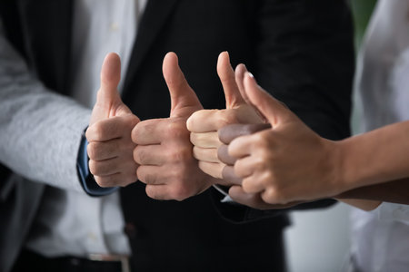 Close up of multiethnic colleagues show thumbs up recommend good quality business service, diverse multiracial coworkers clients give recommendation to course, training, advice, success conceptの写真素材