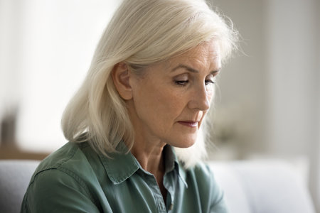 Sad lost blonde elderly lady staring into vacancy, going through loss, grief, depression, bad mental health problems, looking depressed, desperate, frustratedの写真素材