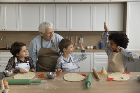 Happy multigenerational family cooking in kitchen. Three cute multiethnic boys prepare homemade...