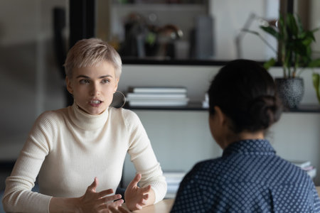Serious vacancy candidate, speaking to employer, hr agent, recruiter at job interview. Confident mentor training intern, explaining project task. Colleagues, business partners meeting and talkingの写真素材