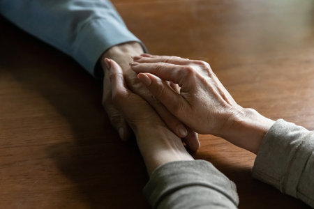 Much needed support. Close up view of aged female wife hands caressing palm of elderly male husband...