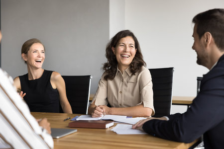 Business team of cheerful colleagues having fun on office brainstorming, talking, discussing success, creative ideas, work project, planning management, strategy, enjoying teamwork, laughingの写真素材