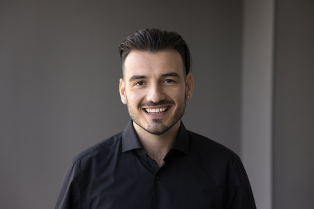 Head shot portrait of young cheerful company employee looking at camera, pose for corporate photo,...