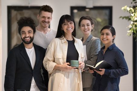Portrait of diverse businesspeople, five bank employee, multiethnic company staff members in formal wear pose standing together in office hallway. Business leadership, professional management, successの写真素材