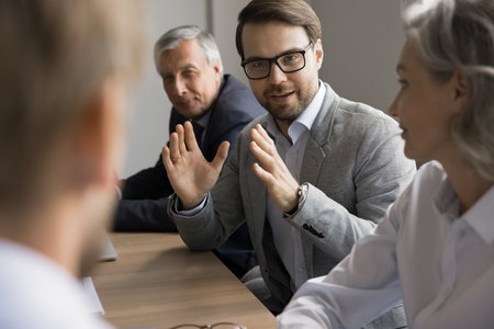 Young businessman, team leader make speech during meeting, participate in decision-making process,...