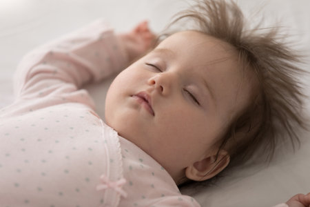 Close up shot serene peaceful adorable baby sleeping lying on bed, above view. Peacefulness of...