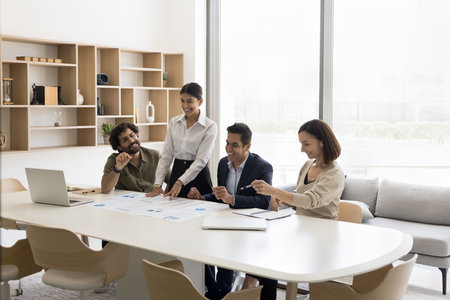 Happy multiethnic staff of bank department analyze statistic materials after successful project. Diverse investors financial analysts team study benchmarking results enjoy perfect startup perspectivesの写真素材