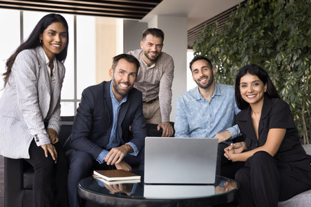 Diverse team of happy business colleagues posing for portrait in office co-working space....