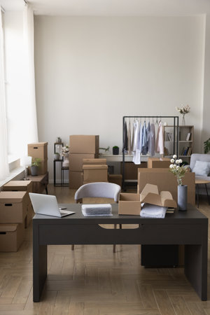 Empty cozy workplace in retail web store internet shop or online marketplace with manager consultant work desk with laptop and storehouse area with packages cardboard boxes to deliver customers orders..の写真素材