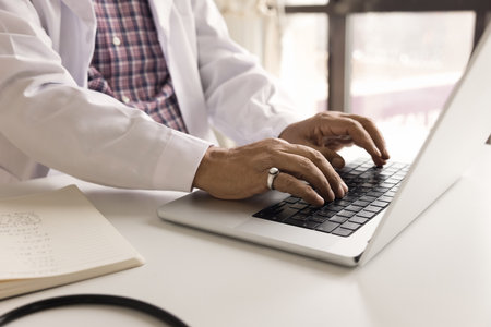 Close up cropped view doctor use laptop, typing e-mail or message to clinic patient, prescribe...