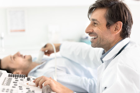 Happy endocrinologist doctor examining patients thyroid for nodes, disease, using modern ultrasound scanner, watching scanning result, smiling, laughing, sharing good news about checkup with manの写真素材