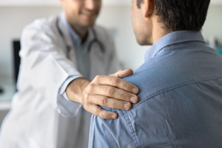 Cropped shot of positive sympathetic doctor touching shoulder of man, congratulating patient on getting better, good examination results, successful treatment, giving support, sympathyの写真素材