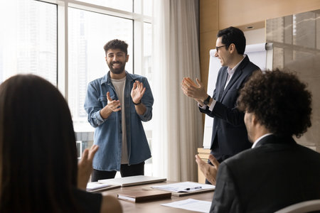 Team welcoming new company member, clap hands finish formal meeting corporate training led by two...