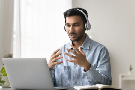 Video call conversation. Confident young male in digital headset talk to customer using notebook...