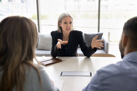 Mature female boss sharing company vision and goals with corporate staff members at briefing, conduct negotiations process with shareholders, make speech, clarifying project timelines, and objectivesの写真素材